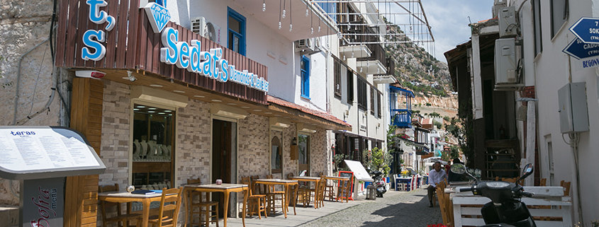 KALKAN, TURKEY - Narrow streets of Kalkan town in Mediterranean Turkey with stone houses cobblestone paved road and restaurants